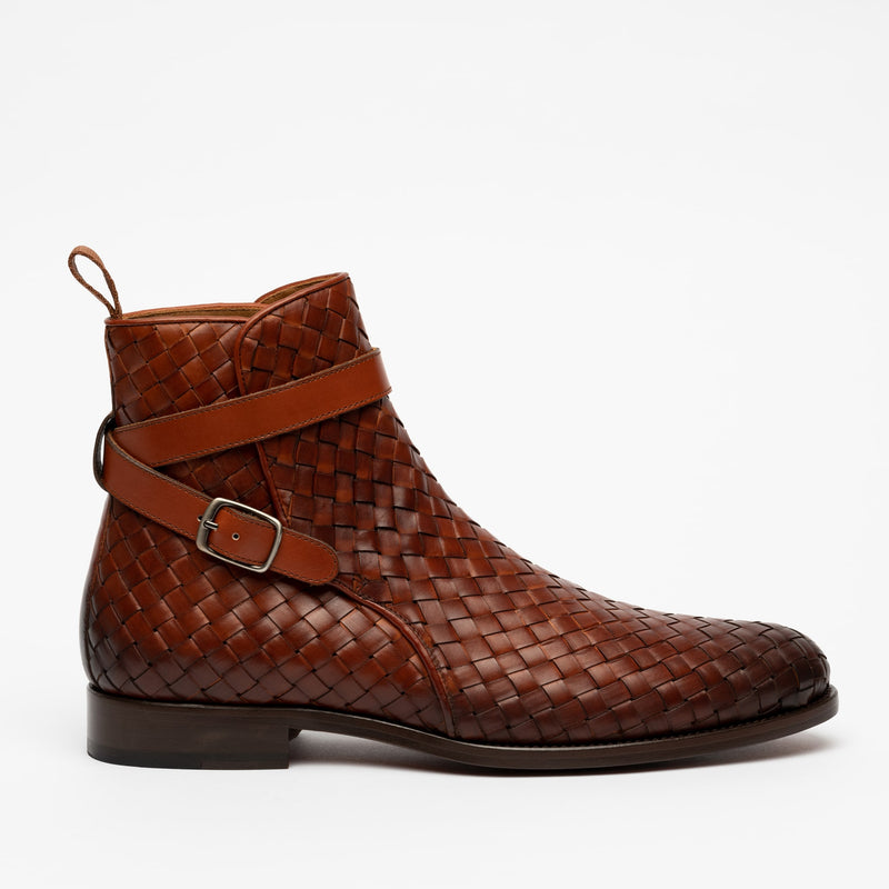 Brown woven leather ankle boot with a side buckle strap and a low heel, shown on a plain white background.
