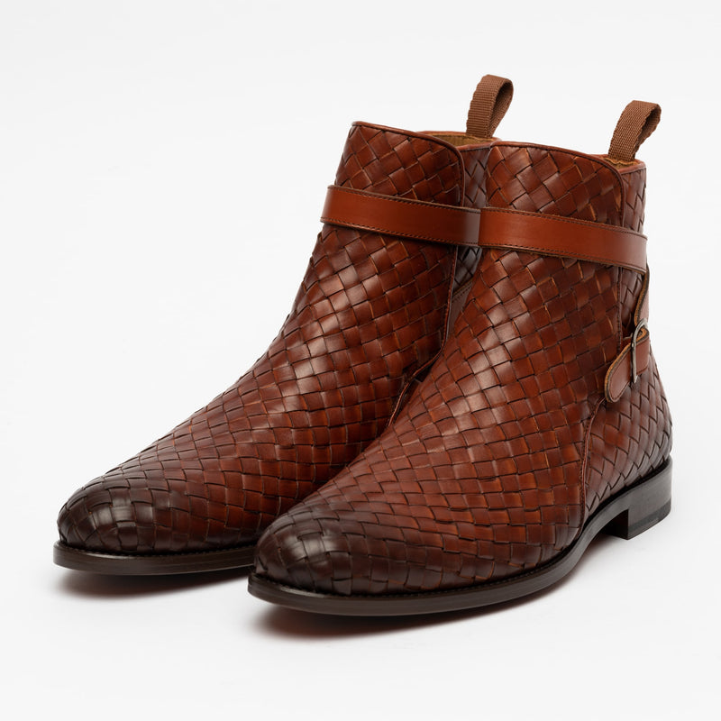 A pair of brown, woven leather ankle boots with side zippers and pull tabs on a plain white background.