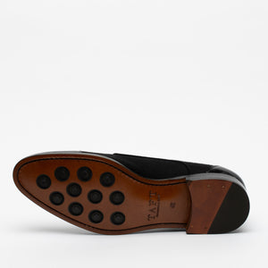 The image shows the bottom of a black and brown men's dress shoe with a leather sole and nine black circular rubber grips. The brand name TAFT is stamped on the sole.