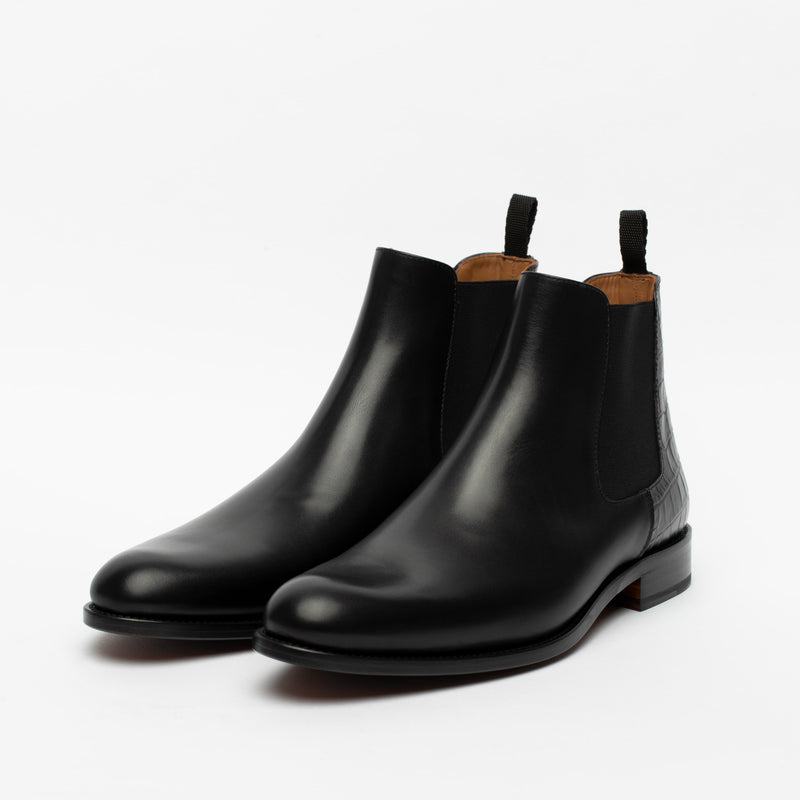 A pair of black leather Chelsea boots with a slight heel and pull tabs, displayed on a white background.